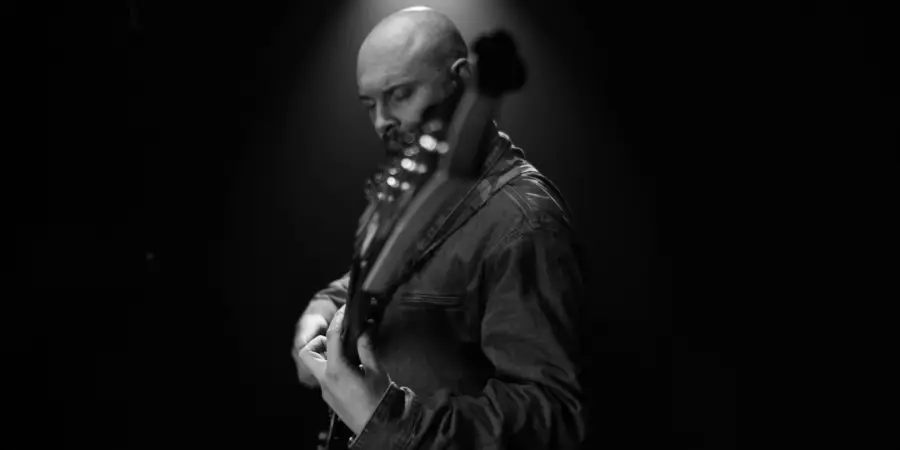 Box of Rules: black-and-white shot playing bass under a single light