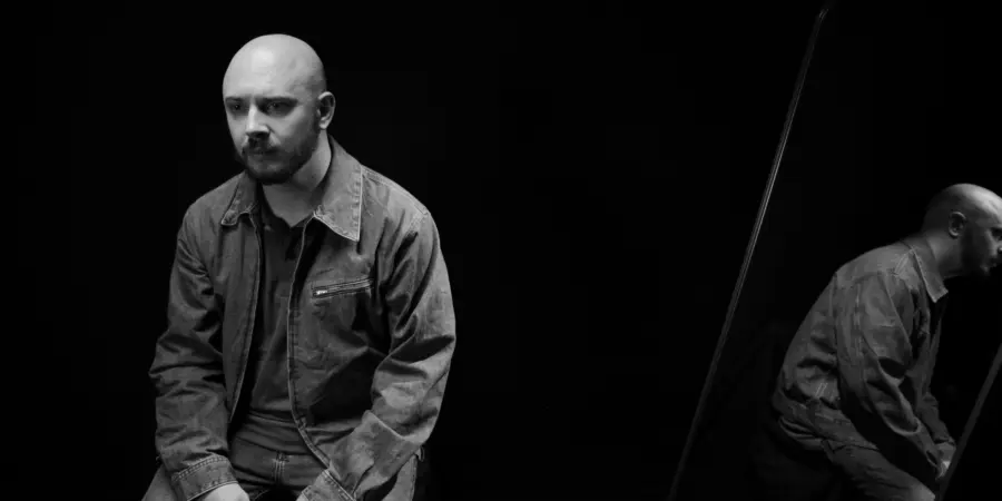 Box of Rules: black-and-white seated portrait with mirror reflection