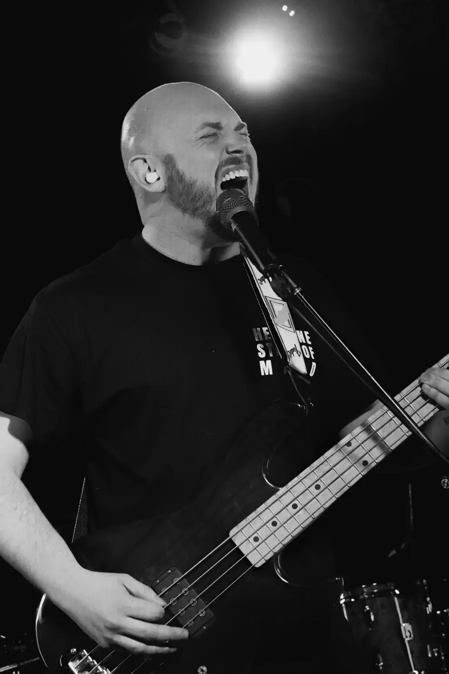 Box of Rules live: singing at the mic, bass in hand — black and white